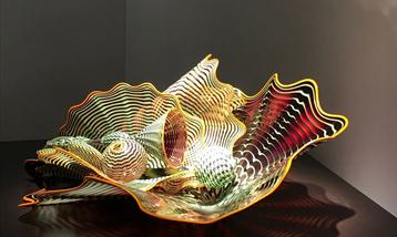 A glass sculpture formed of swirling undulating parallel lines