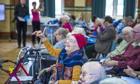 A woman in a wheelchair with her hand in the air.