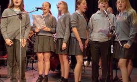 Group of school children singing into microphones