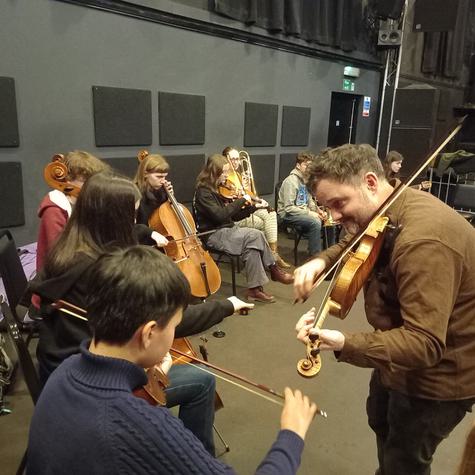 A teacher and young musicians playing together