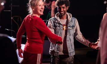 A man and woman smile and shake hands