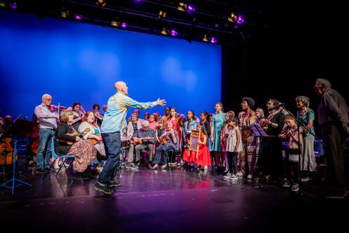 Diverse group of people on stage singing