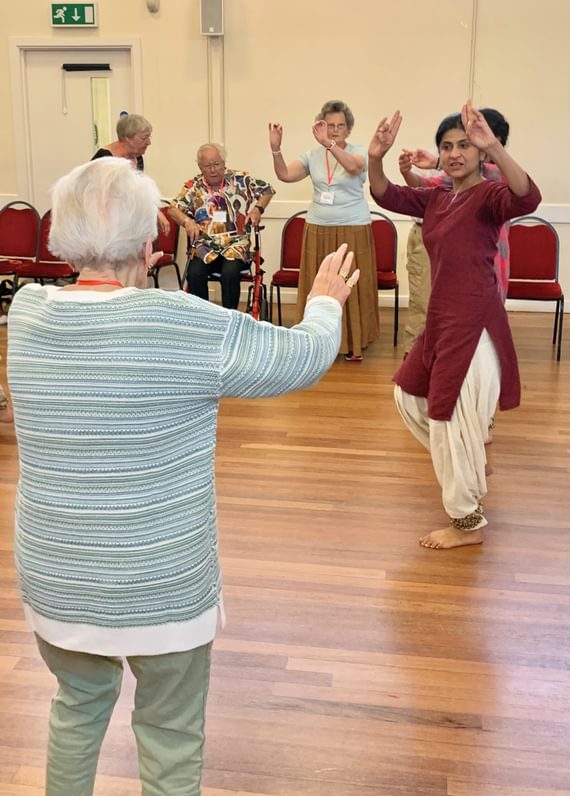 A group of older people dance with instructors