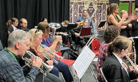 Group of students and musicians seated playing