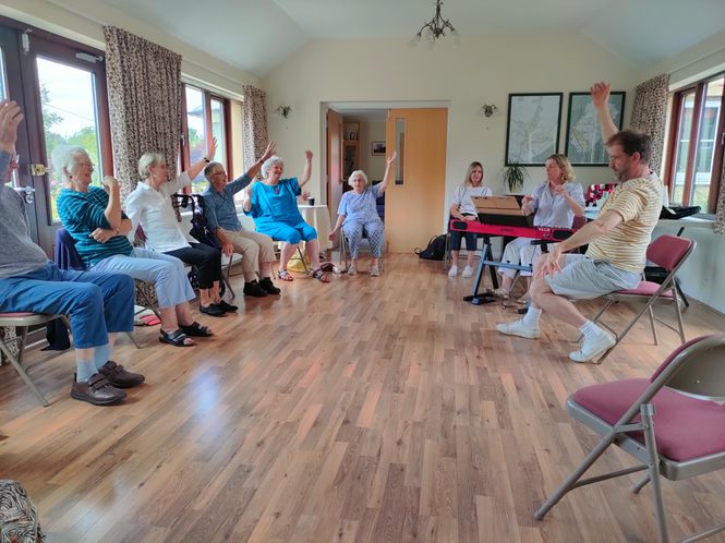 A group of older people seated in a workshop