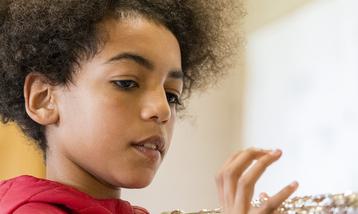 A young girl holding a flute