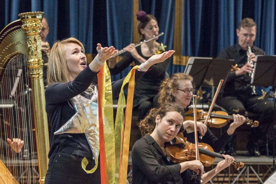 A woman using British Sign Language to interpret a performance by the orchestra.