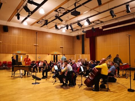 An orchestra playing in a large auditorium