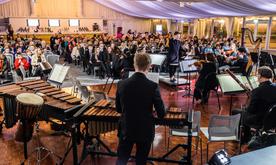Wide shot of concert performance showing musicians and audience